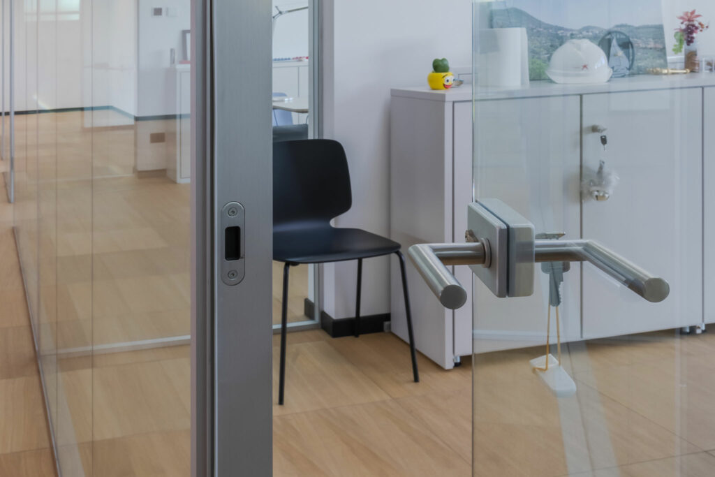 Anta battente a filo lucido, in vetro trasparente da mm 10 temperato.
Serratura con scrocco magnetico, cilindro interno/esterno e coppia di maniglie a leva a bilancino in acciaio inox AISI 304 satinato.